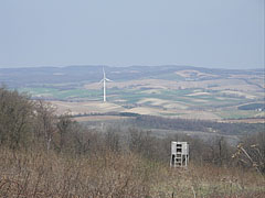 A wooden hunting high-stand in the hillside at the Galamb-berek (grove), as well as a wind turbine in the valley (near Szápár settlement) - Bakony Mountains, Maďarsko