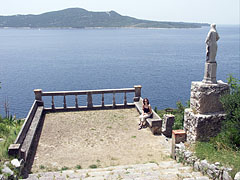 View to the Adriatic Sea and the Lopud Island ("Otok Lopud") from the stairs of the rocky hillside; in the foreground there is a spacious stone terrace with a statue of St. Balise beside it - Trsteno, Chorvatsko