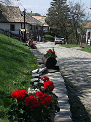 A street paved with natural stone, decorated with geranium flowers - Hollókő, Macaristan