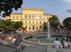 The surroundings of the great music fountain is a famous relaxing and meeting place, and behind it the yellow main building of the University of Szeged is bathing in the sunlight  - Szeged, Macaristan