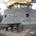 The stone-made lowest level of the Várhegy Lookout Tower, in front of it there are wooden benches and a table - Fonyód, Hungria