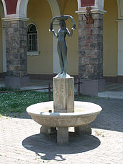 "Girl with fish" statue in an ornamental fountain in front of the thermal bath archway - Szolnok, Hungria