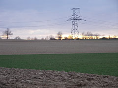 Plowed field with a transmission tower or electricity pylon at sunset - Eplény, Ungheria