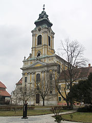 The Assumtion of Virgin Mary Church on the main square, as well as the half-length statue of Kálmán Széll Hungarian parliamentarian and prime minister (1843-1915) in front of it - Szentgotthárd, Унгария