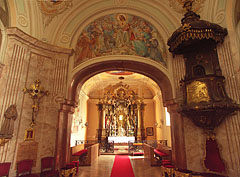 Looking towards the sanctuary: upwards a splendid fresco, on the right the carved wooden pulpit can be seen - Gödöllő, Ungari