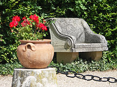 Stone bench and a vase with geranium flowers in the garden of the Széchenyi Mansion of Nagycenk - Nagycenk, Ungari