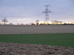 Plowed field with a transmission tower or electricity pylon at sunset - Eplény, هنغاريا