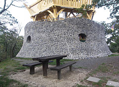 The stone-made lowest level of the Várhegy Lookout Tower, in front of it there are wooden benches and a table - Fonyód, Мађарска