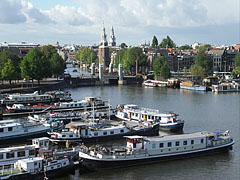 The port, the Klikkerbilsluis sluice (this English word comes from the Dutch "sluis"), and the Montelbaan Tower behind it (at the beginning of the Oudeschans canal), viewed from the NEMO - Amsterodam, Nizozemsko