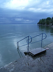 One of the stairs of the free beach, in the distance storm clouds of a supercell are gathering over the lake - Balatonföldvár, Macaristan