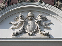 Stone carved coat of arms of Hungary with the crown and two angels or putti, on the main facade of the palace - Gödöllő, Węgry