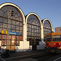 The newer, ferro-concrete train station building of Mátészalka with arched roof, and a train (a "BZMOT" model) in front of it - Mátészalka, Mađarska