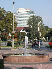 Szökőkút, távolban a négycsillagos Ramada Hotel & Resort Lake Balaton szálloda magas épülete - Balatonalmádi, Magyarország