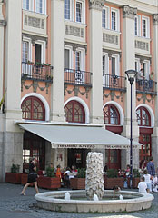 The Tiramisu Café on the ground floor of the former Hotel Mátra, next to it there's a fountain with a grapevine sculpture - Gyöngyös, Maďarsko