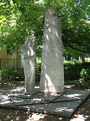 Statue of a mourning female figure who shut herself up, it is a World War II memorial under the trees - Siófok, Macaristan