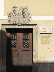 The door of the County Library was built in the late 18th century, above there are some carved crests - Pécs, Ungaria