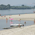 Many people bathing in the water of the Danube, which is here in the gravel deposit bays shallow, gently deepening and in the summertime warm as well - Dunakeszi, Hongarije