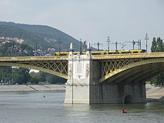 A Margit híd középső pillére a Margit-szigetnél, a hídon pedig épp egy sárga Combino villamos halad át - Budapest, Magyarország