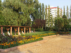 Flowered park, and further away the "Tulipán House" ("Tulip House") holiday resort in the Napospart Street can be seen - Balatonlelle, Maďarsko