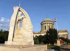 The statue called „Crowning Saint Stephen I” (king of Hungary) by Miklós Melocco and the dome of the cathedral in the sunset - Esztergom, Hungria