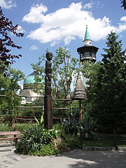 Wooden column-sculpture with African ground idols, and the Elephant House with its observation tower can be seen in the distance as well - Budapest, Ungheria