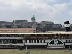 The "Kossuth" museum and restaurant boat, including the "Vénhajó" Restaurant, the background of the photo is filled with the huge Royal Palace in the Buda Castle - Budimpešta, Madžarska