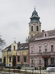 Shops on the main square with the tower of the Roman Catholic church in the background - Szentgotthárd, هنغاريا